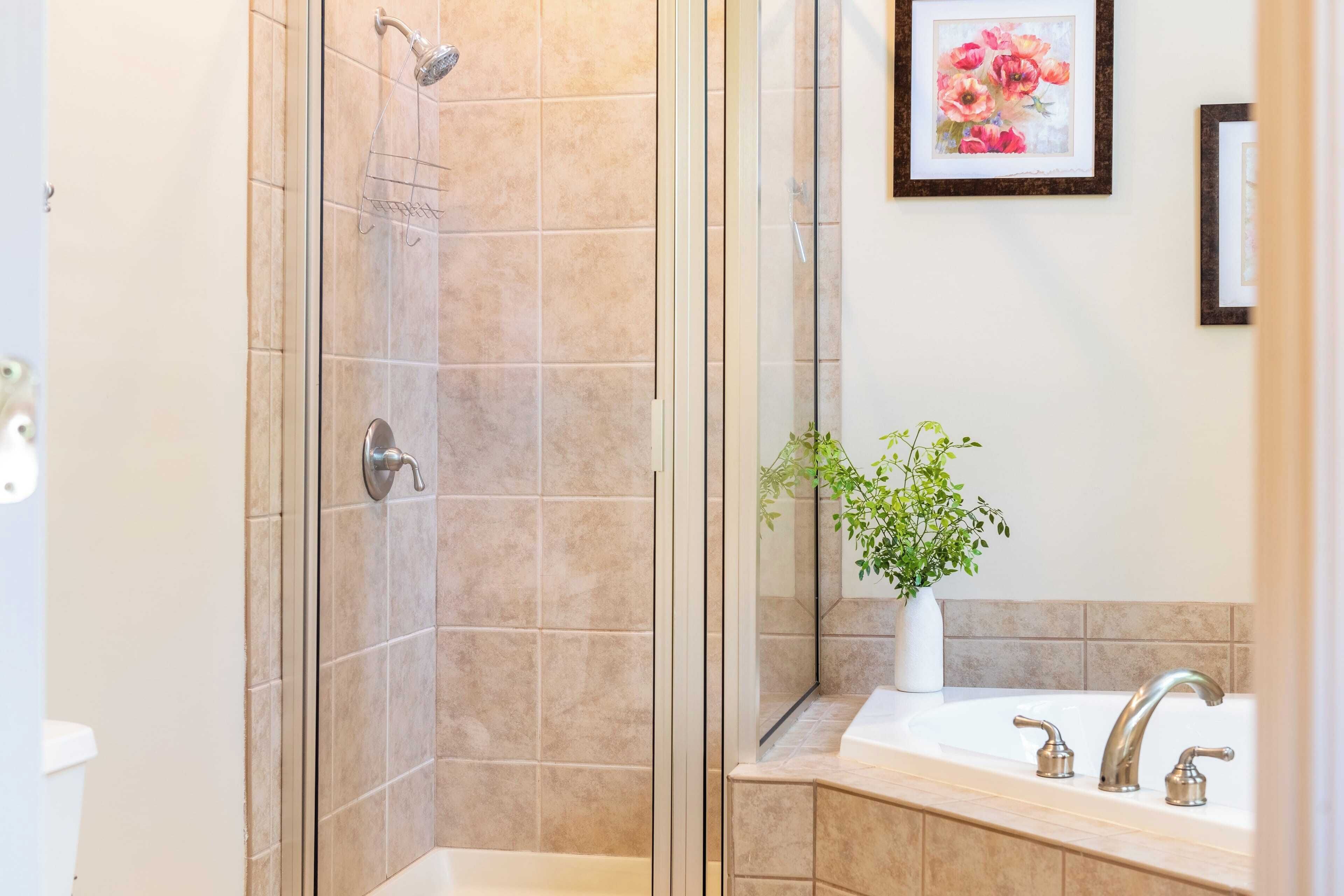 A bathroom with a shower, a sink, and a mirror.