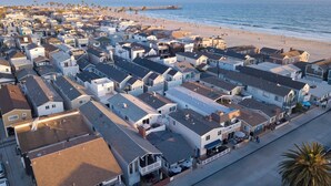 Un pueblo costero con playa, casas y un muelle.
