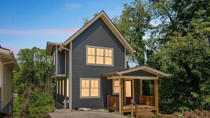 A two-story house with a porch and a covered entryway.