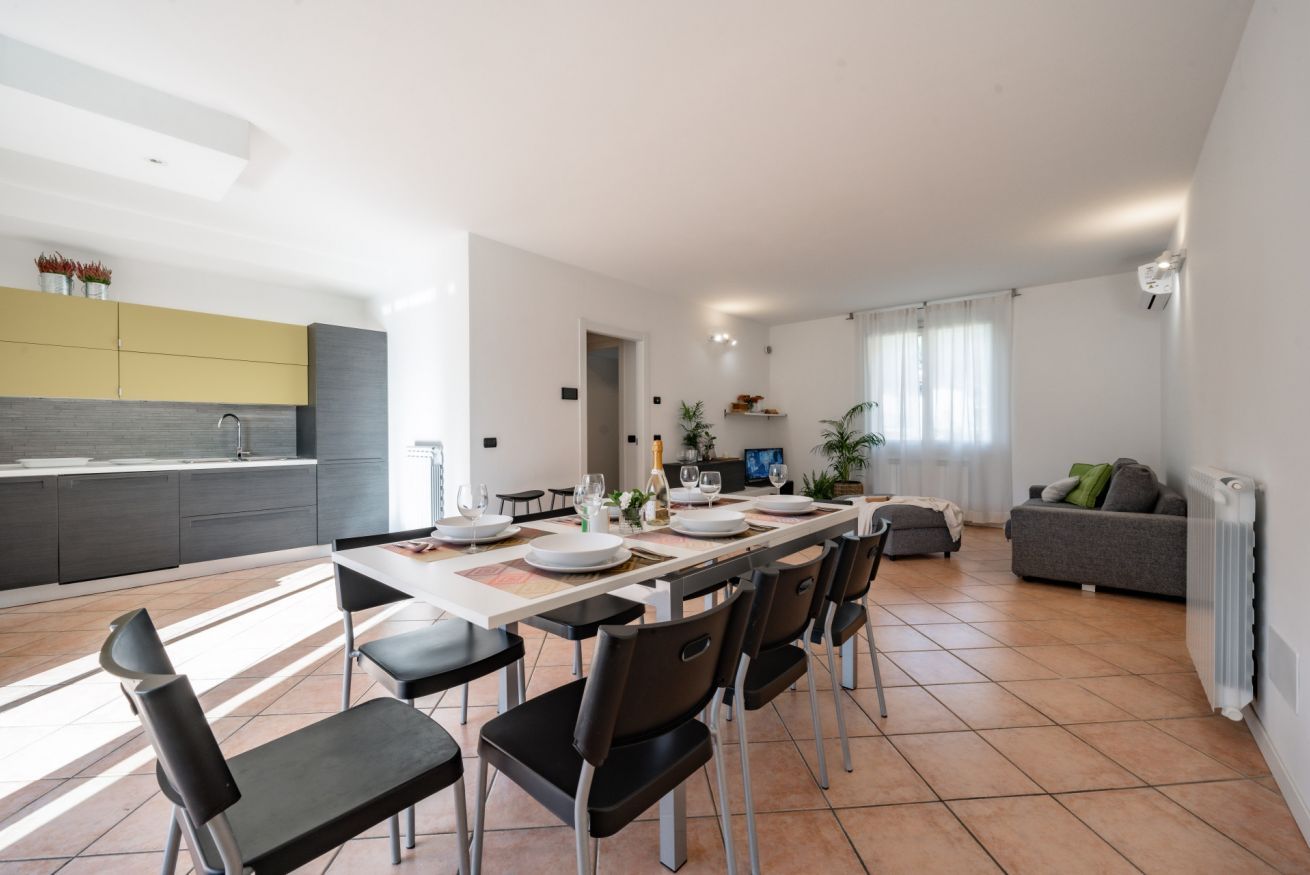 Une cuisine moderne avec un coin repas, un salon avec un canapé et un téléviseur.