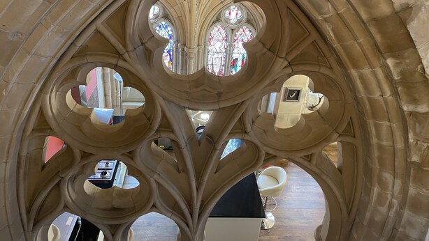 L’intérieur d’une cathédrale, avec ses arcs gothiques et ses vitraux.