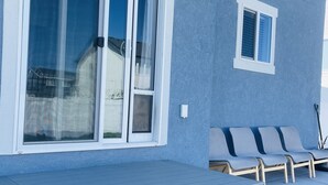 A modern outdoor seating area with a built-in bench and steps leading to a covered patio. - Hot Tub - Cozy Retreat in Springville (Springville)