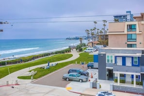 A coastal residential area with a paved walkway, parked cars, and a view of the ocean. - New Low Rates Len and Marys Beach Front 2 BD Condo (San Diego)