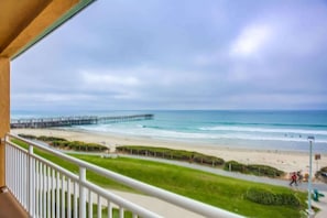 A balcony with a view of a beach, a pier, and a clear sky. - New Low Rates Len and Marys Beach Front 2 BD Condo (San Diego)
