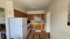 A compact kitchen with wooden cabinets, a white refrigerator, and a microwave. - Cozy 1Bed/1Bath unit, Pets OK, Close to ProMedica, UT. (Toledo)
