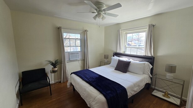 A bedroom with a bed, a chair, a ceiling fan, and two windows with curtains. - Cozy 1Bed/1Bath unit, Pets OK, Close to ProMedica, UT. (Toledo)