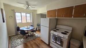A compact kitchen with a stove, refrigerator, and a dining table with chairs. - Cozy 1Bed/1Bath unit, Pets OK, Close to ProMedica, UT. (Toledo)