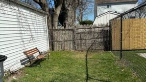 A fenced backyard with a bench, a tree, and a house in the background. - Cozy 1Bed/1Bath unit, Pets OK, Close to ProMedica, UT. (Toledo)