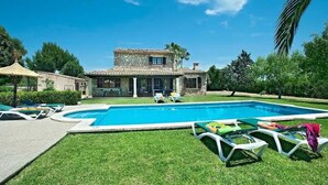 A pool with lounge chairs, a stone house, and a clear blue sky. - Villa 'Colet Vell' with Private Pool, Wi-Fi and Air Conditioning (Illes Balears)