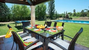 An outdoor dining area with a pool in the background. - Villa 'Colet Vell' with Private Pool, Wi-Fi and Air Conditioning (Illes Balears)