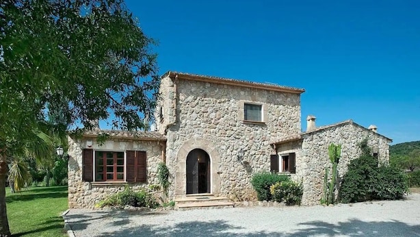 A stone building with a central entrance, a small window, and a chimney. - Villa 'Colet Vell' with Private Pool, Wi-Fi and Air Conditioning (Illes Balears)