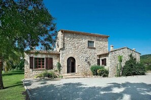 A stone building with a central entrance, a small window, and a chimney. - Villa 'Colet Vell' with Private Pool, Wi-Fi and Air Conditioning (Illes Balears)