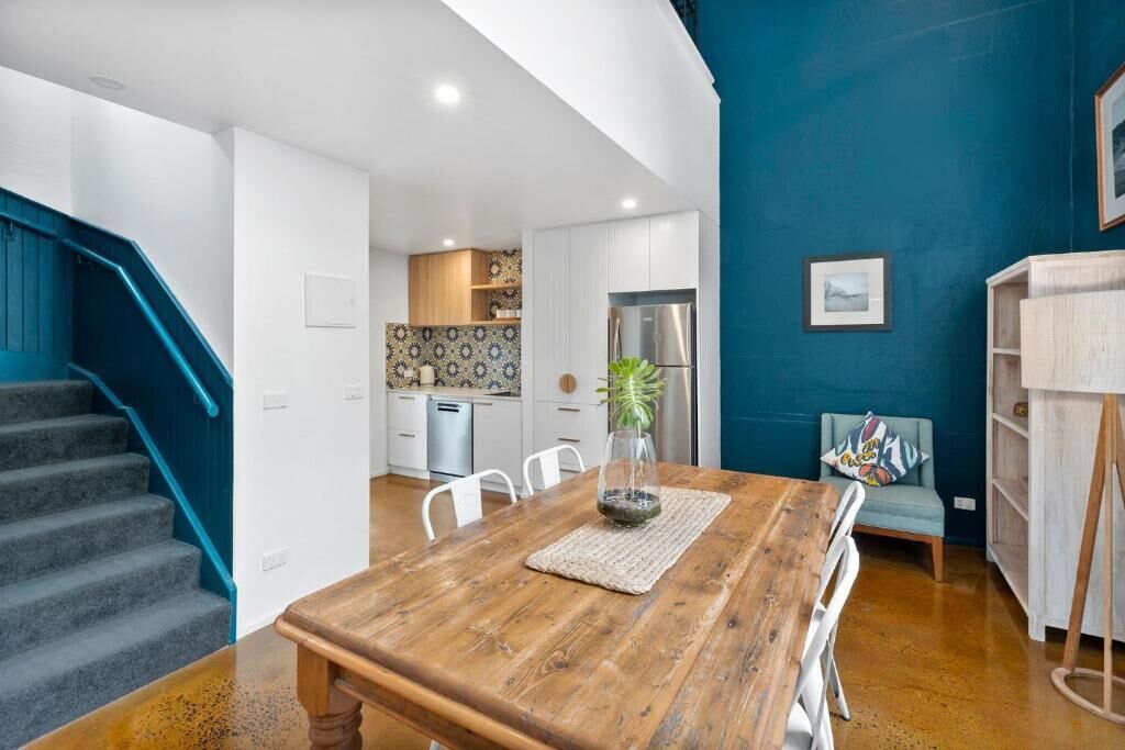 A modern kitchen with white cabinets, a stainless steel refrigerator, and a patterned backsplash.