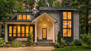A two-story house with a front porch, large windows, and a well-maintained garden.