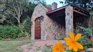 Un edificio de piedra con puerta de madera y chimenea.