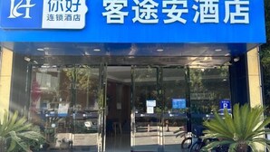 A hotel entrance with a blue sign, glass doors, and potted plants outside. - Ketouan Hotel (Yangzhou Slender West Lake Branch) (Yangzhou)