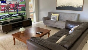 Un salon avec une télévision, un canapé, une table basse et une télécommande.