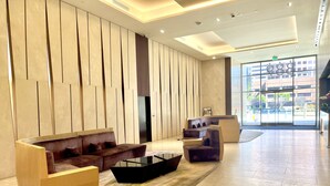 Un lobby moderno con un sofá curvo, una mesa de centro y un mostrador de recepción.
