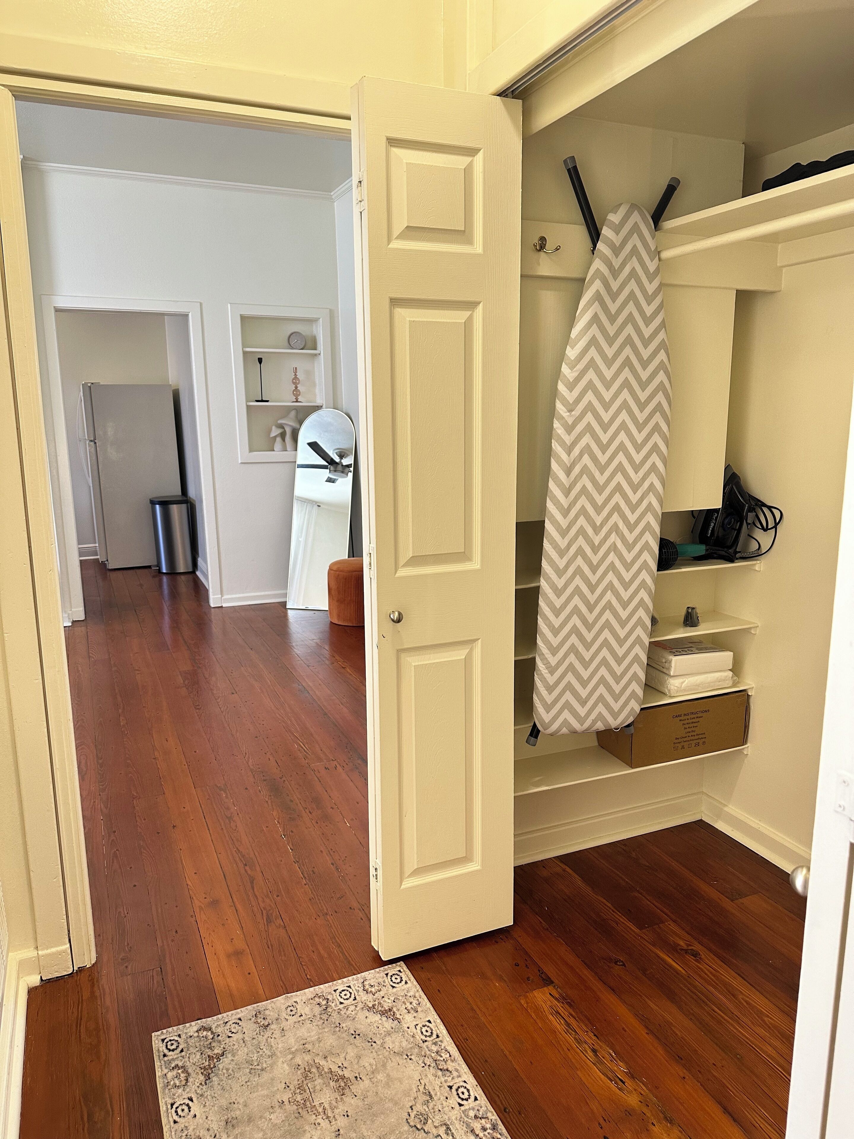 Un passadís amb terra de fusta que condueix a una habitació amb una porta blanca.