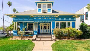 A two-story building with a blue facade and a central entrance. - High Ceiling, Cozy 1BR Apt, Walk to Metro & Shops (Pasadena)