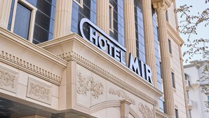 A hotel sign with the name "HOTEL MIR" on a classical building facade with ornate detailing. - mir hotel (Sokcho)