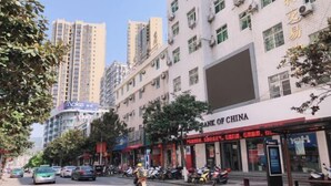 A street view with a row of buildings, including a bank and a Moke store. - IKEA Express Hotel Xunyang (Xunyang)