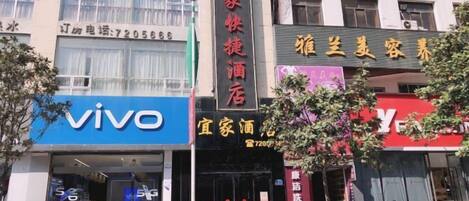 A building with a 'vivo' sign, a '家家快捷酒店' sign, and a '雅兰美美容' sign.