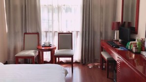 A hotel room with a bed, two chairs, a desk with a computer, a lamp, and a large mirror. - IKEA Express Hotel Xunyang (Xunyang)