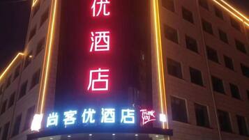 Une enseigne d’hôtel avec des caractères chinois et une enseigne lumineuse au néon.