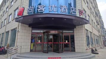 A hotel entrance with a curved facade, glass doors, and a sign above the entrance.