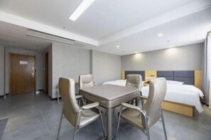 A hotel room with a bed, a table, and four chairs. - Shankee Hotel (Linyi Xianggong) (Linyi)