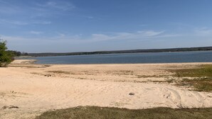 A beach with a sandy shore and a calm body of water.