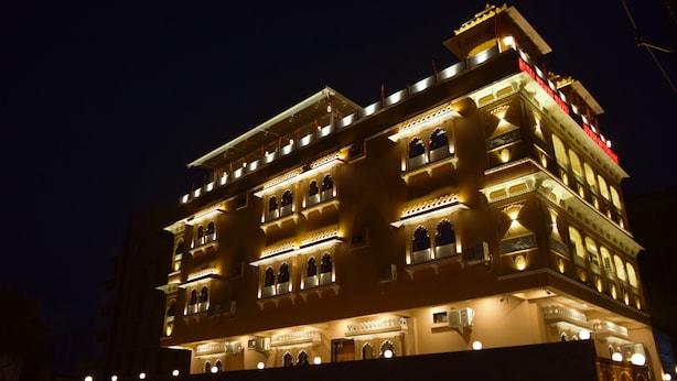 A multi-story building with illuminated balconies and windows, featuring traditional architectural elements. - Hotel Mewar Mahal - Udaipur (Udaipur)