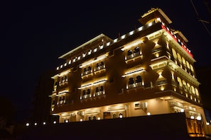 A multi-story building with illuminated balconies and windows, featuring traditional architectural elements.