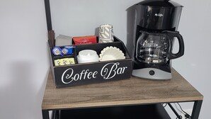 A coffee bar setup with a coffee maker, microwave, and storage boxes labeled "Coffee Bar". - Cozy boathouse located at the Cedar Point entrance!  (Sandusky)
