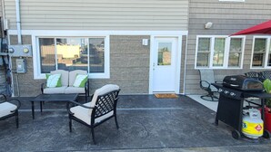 A patio with outdoor furniture, a grill, and a stone wall. - Cozy boathouse located at the Cedar Point entrance!  (Sandusky)