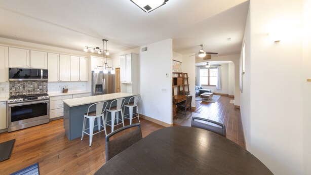 A modern kitchen with white cabinets, stainless steel appliances, and a central island with bar stools. - Main Street Carbondale Townhome.  Super Convenient.
 (Carbondale)