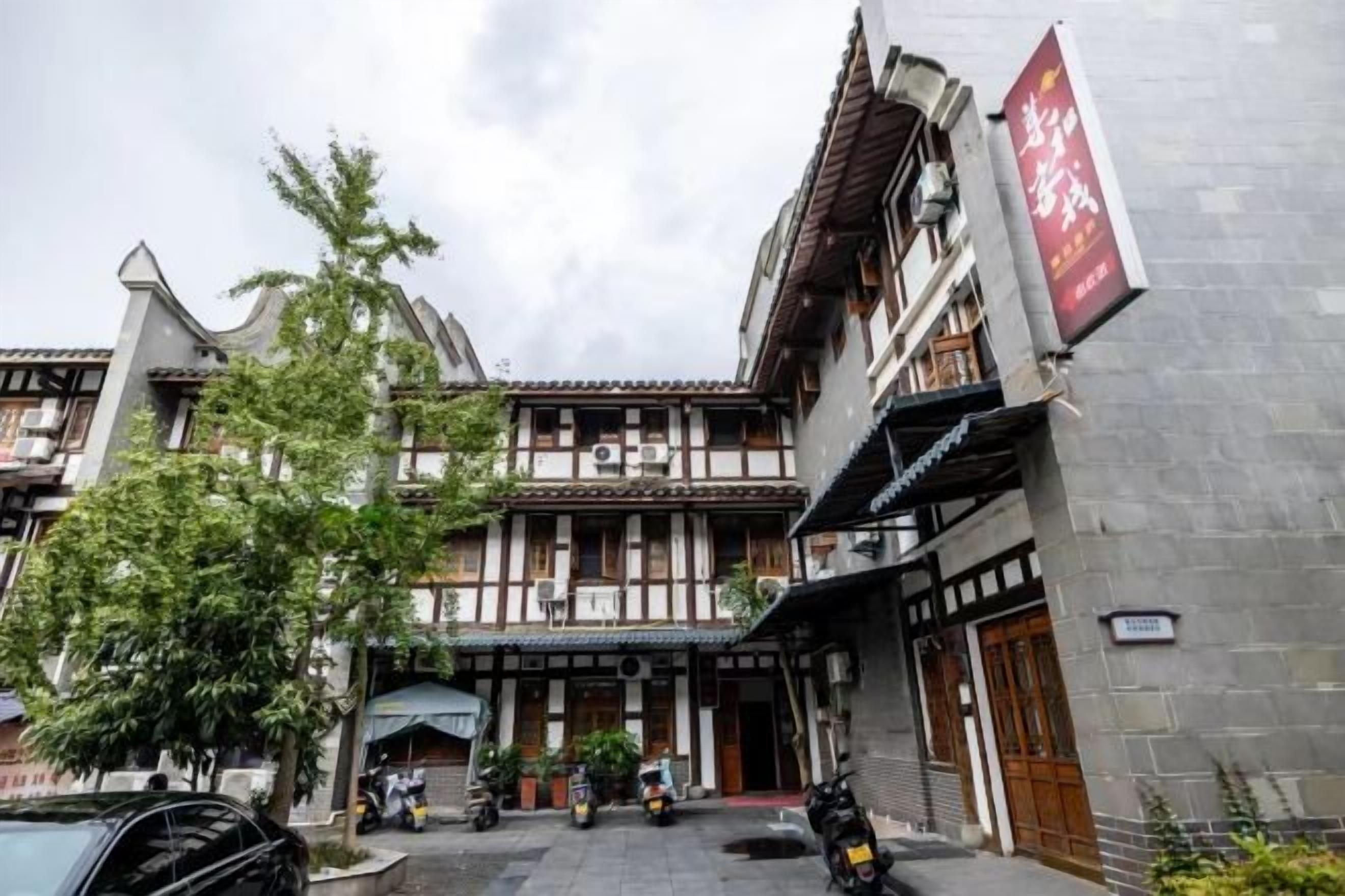 A traditional building with a courtyard, multiple doors, and a signboard.