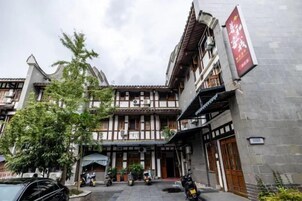 Un edificio tradicional con un patio, varias puertas y un cartel.