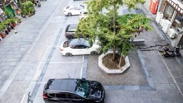A parking lot with cars and a tree.