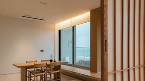 Una habitación moderna con un ventanal grande, una mesa de madera y sillas.