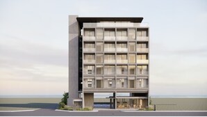 Un edificio moderno de varios pisos con techo plano, ventanas grandes y acceso al nivel de la calle.