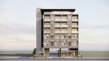 Un edificio moderno de varios pisos con techo plano, ventanas grandes y acceso al nivel de la calle.