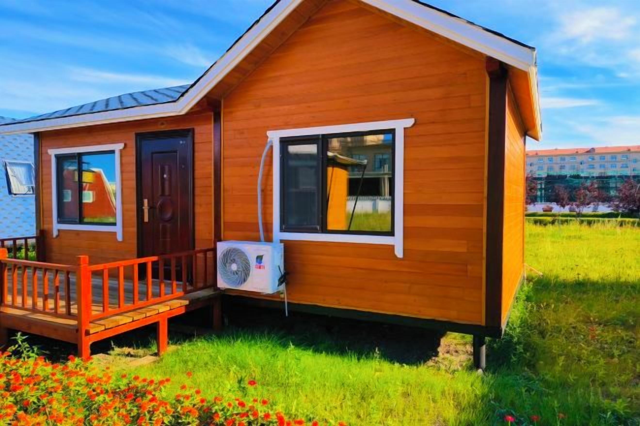 A wooden cabin with a porch, a door, and a window.