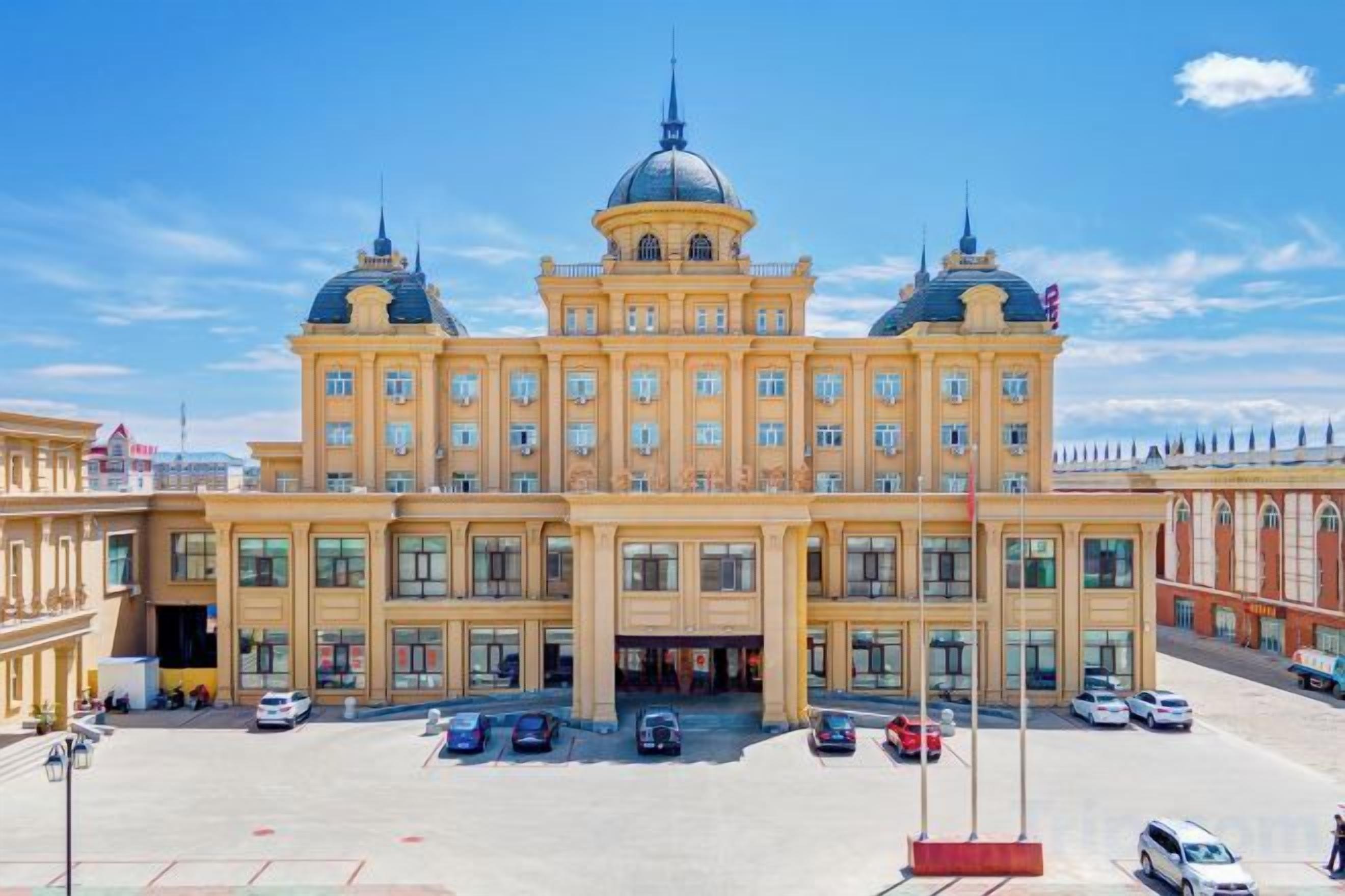 A large, historic building with a symmetrical facade, multiple windows, and a central dome.