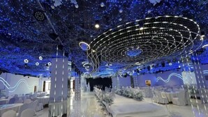 A banquet hall with a circular stage, rows of tables, and chairs. - Manzhouli Jinlongquan Hotel (Zhayanuoer Museum) (Hulunbuir)