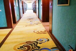 Un pasillo de hotel con piso alfombrado y puertas a ambos lados.