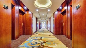 A long, narrow hallway with wooden doors on either side and a patterned carpet. - Manzhouli Jinlongquan Hotel (Zhayanuoer Museum) (Hulunbuir)