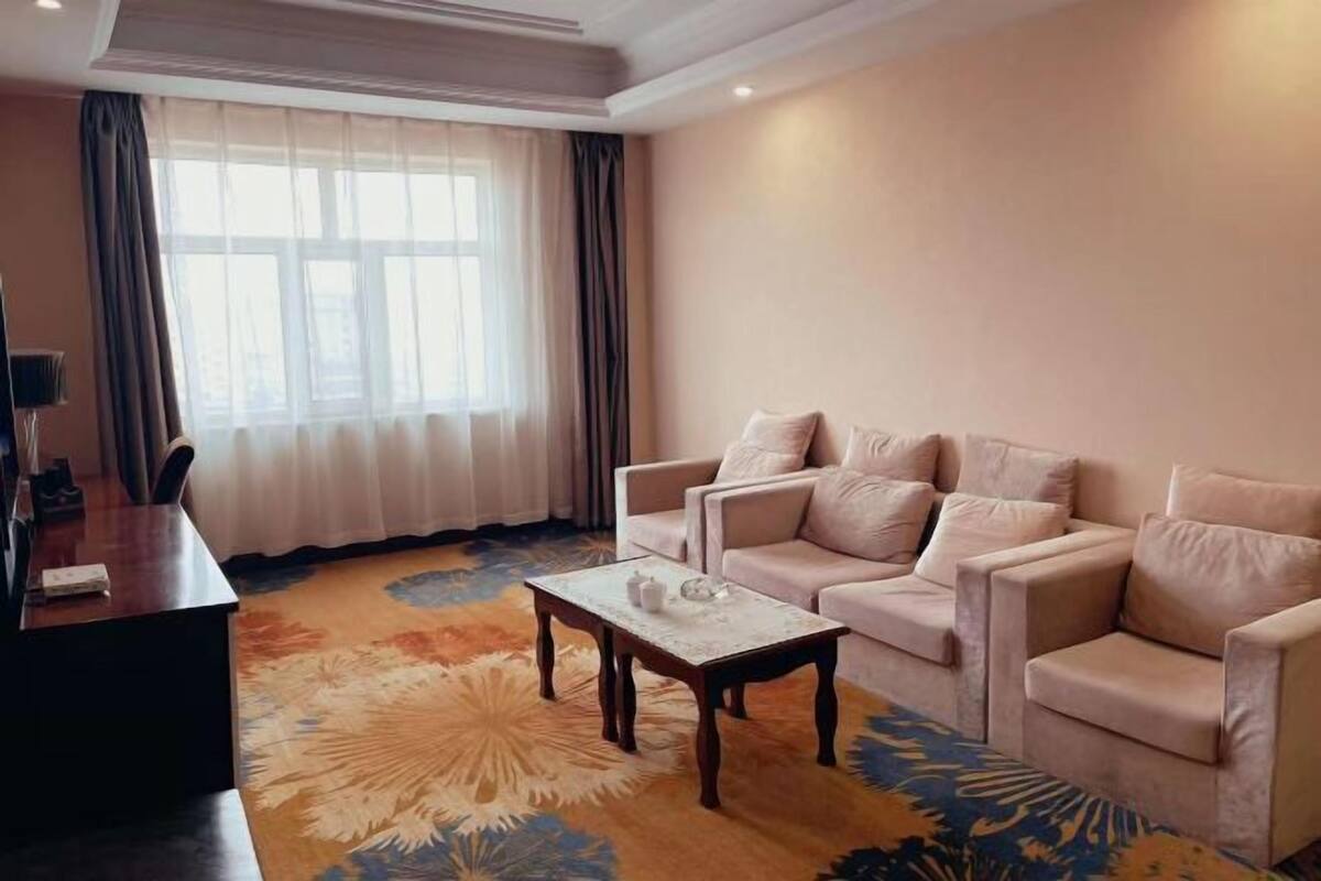 A living room with a sofa set, a coffee table, and a desk with a lamp.