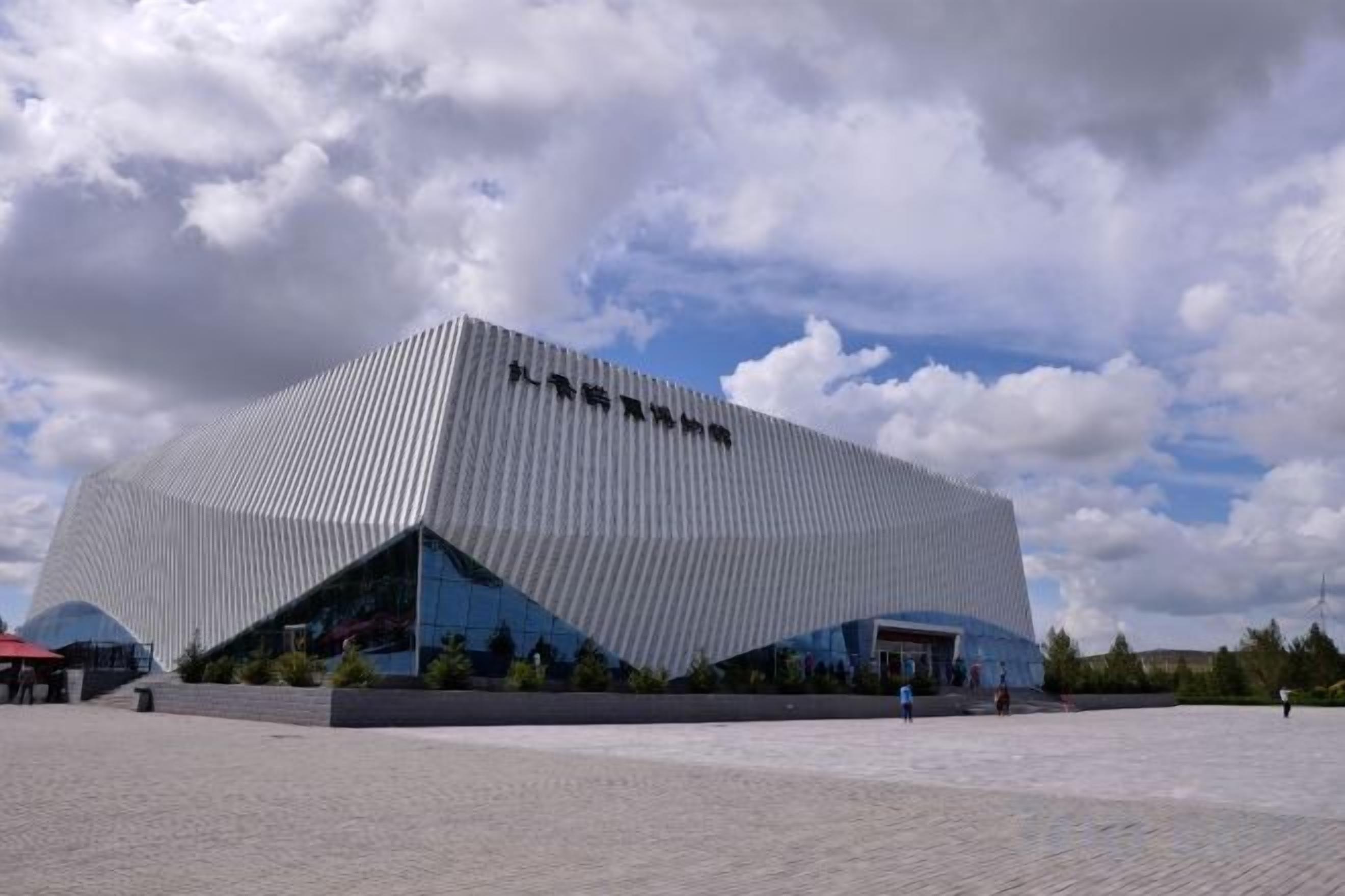 Un bâtiment moderne au design angulaire original, doté d’une entrée imposante et d’un vaste espace extérieur.